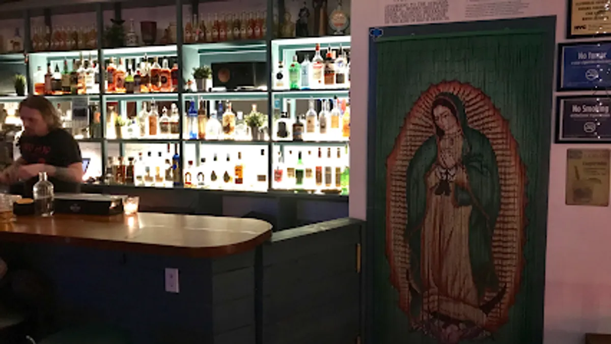 Interior view of El Santo restaurant in Brooklyn, showcasing vibrant decor and diners enjoying meals